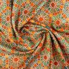 Detalle fular estampado con patrón geométrico de mocárabes en tonos naranjas y verdes